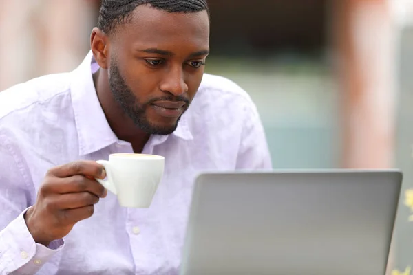 Hombre Con Piel Negra Revisando Laptop Tomando Café Una Terraza —  Fotos de Stock