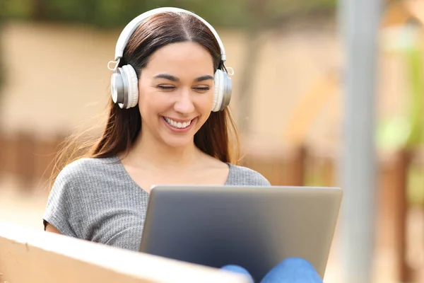 Happy Woman Using Laptop Sitting Bench Headphones Park — ストック写真