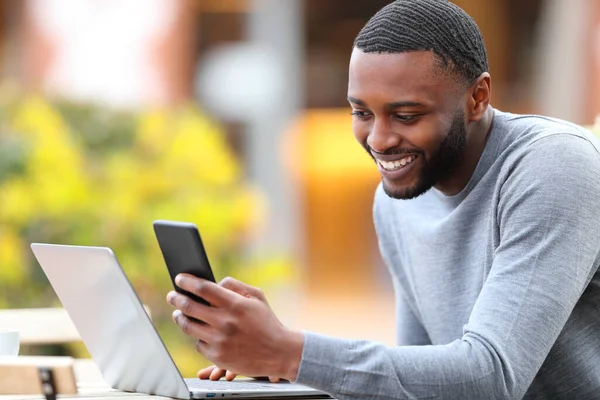 Happy Man Black Skin Checking Mobile Phone Laptop Bar Terrace —  Fotos de Stock