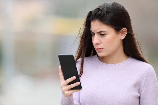 Besorgte Frau Liest Smartphone Inhalte Auf Der Straße — Stockfoto