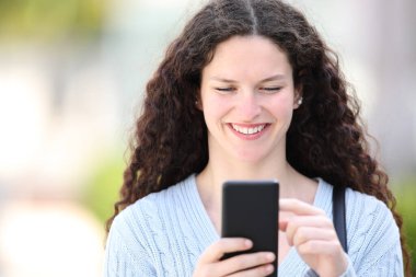 Sokakta telefonla dolaşan bir kadının portresi.