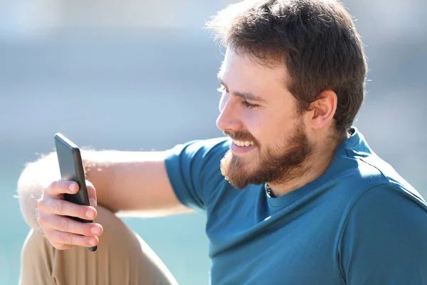Glücklicher Mann Liest Nachricht Auf Smartphone Sitzend Der Natur — Stockfoto