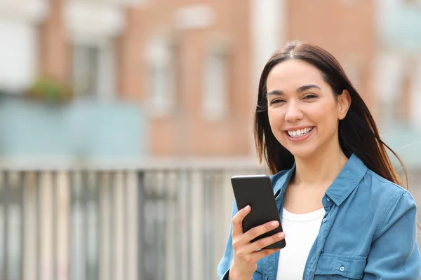 Mulher Feliz Olhando Para Câmera Segurando Telefone Inteligente Rua — Fotografia de Stock