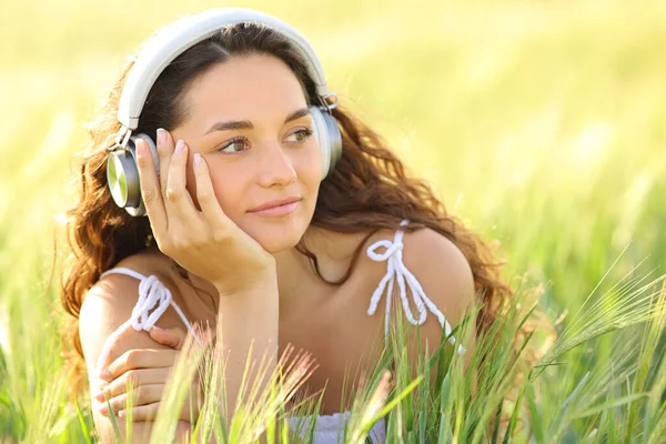 Ontspannen Vrouw Met Koptelefoon Luisterend Naar Muziek Kijkend Naar Kant — Stockfoto
