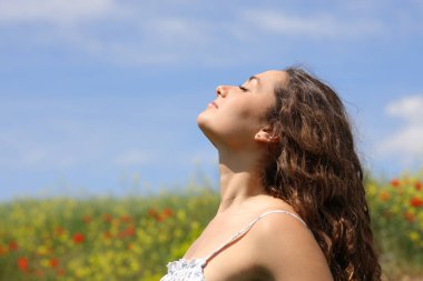Side view portrait of a woman breathing in a flowers field