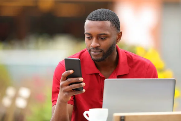 Kırmızılı Siyah Adam Kahve Dükkanının Terasında Telefon Laptop Kullanıyor — Stok fotoğraf