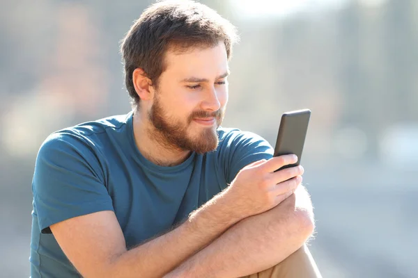 Satisfied Man Reading Mobile Phone Content Outdoors — Photo