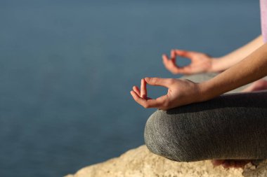Clos eup of a yogi hands doing yoga exercise in a lake