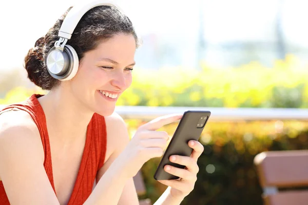 Mulher Feliz Sentado Banco Parque Ouvindo Música Verifica Telefone Inteligente — Fotografia de Stock