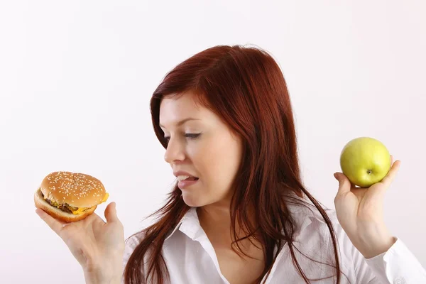 Jonge vrouw met hamburger en apple — Stockfoto