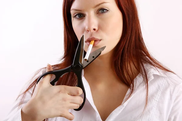 Young woman cutting cigarette in half isolated over white — Stock Photo, Image