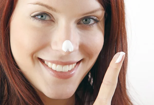 gülümseyen kadın nemlendirici krem burnuna koy.