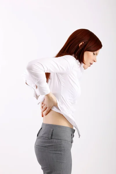 Young woman holding her back, having pain — Stock Photo, Image