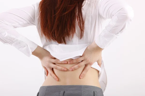 Jovem mulher segurando as costas, com dor — Fotografia de Stock