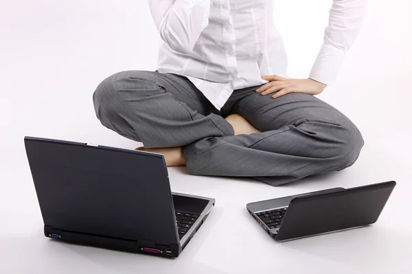 A businesswoman is using her laptops sitting on the ground. — Stock Photo, Image