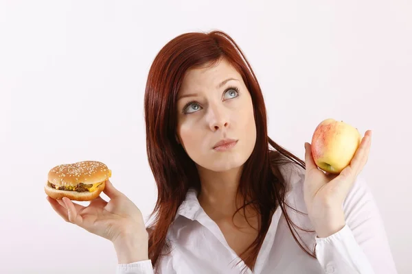 Young woman with hamburger and apple Royalty Free Stock Photos
