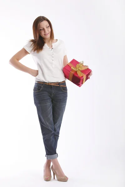 Menina posando em uma camiseta branca e jeans com uma caixa com presentes — Fotografia de Stock