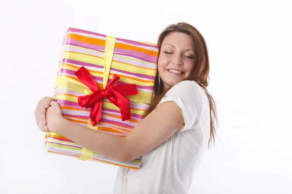 Girl posing in a white T-shirt and jeans with a box with gifts — Stock Photo, Image