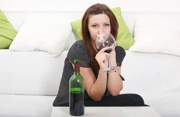 Tjej dricker vin intill soffan — Stockfoto