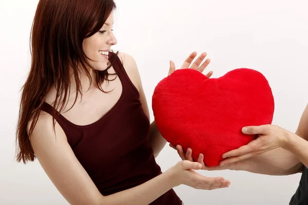 Girl with a heart-shaped pillow — Stock Photo, Image