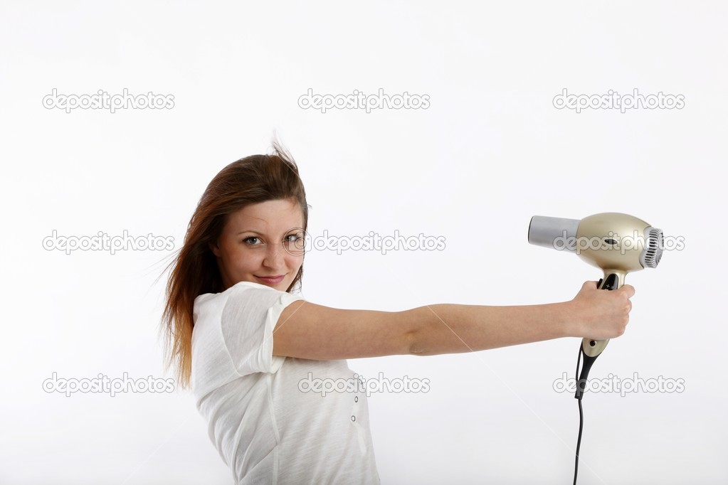 Mão de menina segurando o secador de cabelo.