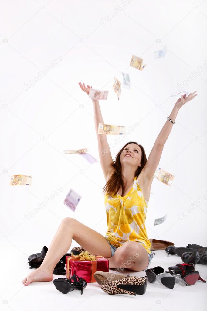 Girl sitting on the floor with shoes, gifts and throwing money