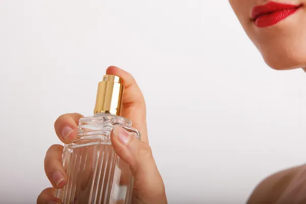 Imagen recortada de una linda joven con una botella de perfume en la mano . — Foto de Stock