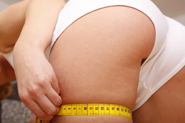 Zeštíhlující žena měření její tělo — Stock fotografie