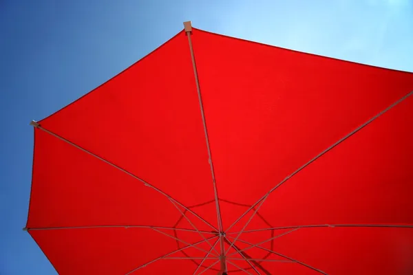 Red umbrella in a clear blue sky — Stock Photo, Image