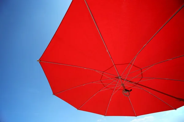 Red umbrella in a clear blue sky — Stock Photo, Image