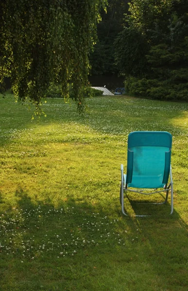 Eenvoudige chaise lounge op het groene gras — Stockfoto