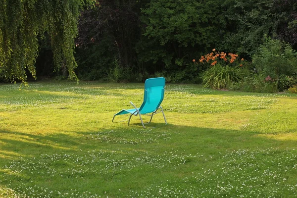 Simple chaise lounge on the green grass — Stock Photo, Image