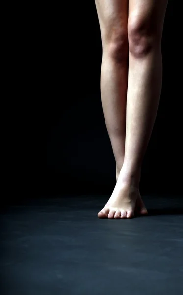 Female feet on a dark background — Stock Photo, Image