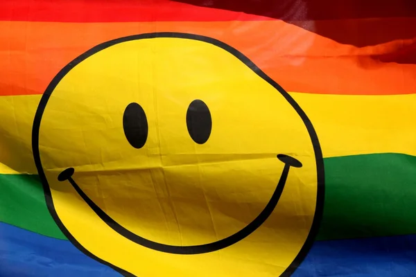 Smiley auf Regenbogenhintergrund — Stockfoto