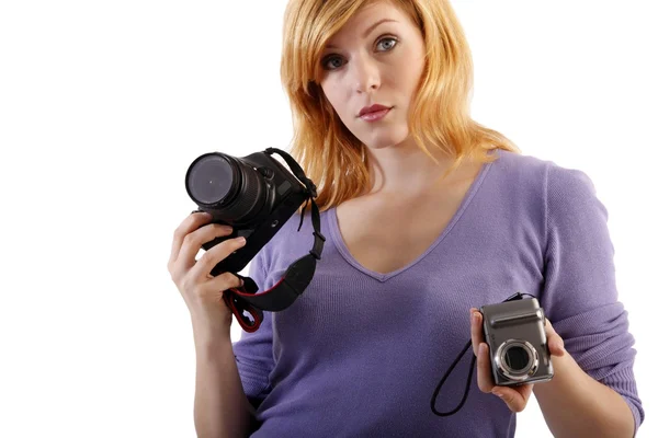 Она держит однообъективную рефлекторную камеру и компактную камеру — стоковое фото