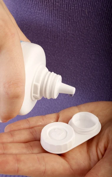 Jonge vrouw met contactlenzen gevallen en fles van schoonmaak vloeistof — Stockfoto