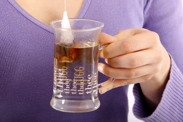 Chica pone una bolsita de té en la taza con agua caliente —  Fotos de Stock