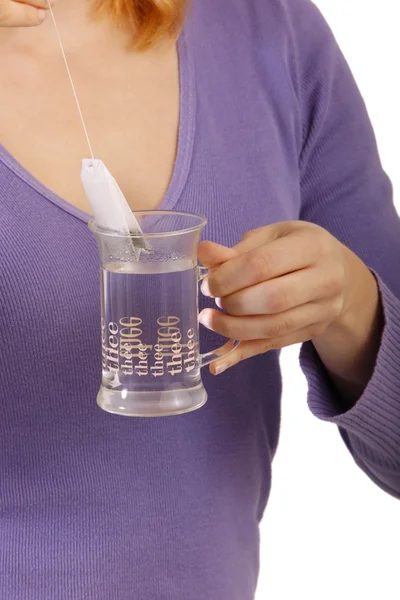 Chica pone una bolsita de té en la taza con agua caliente — Foto de Stock