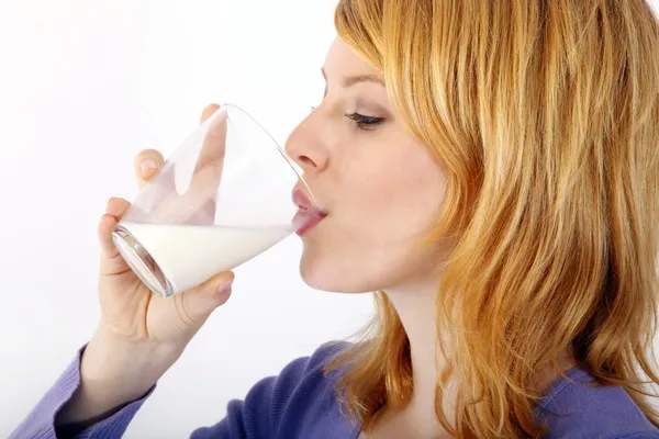 Beautiful blond woman with a glass of milk — Stock Photo, Image