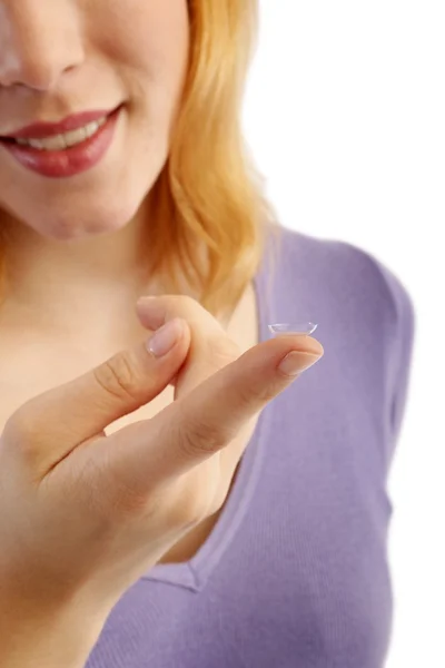 Meisje houdt de vinger op een contactlens Stockafbeelding