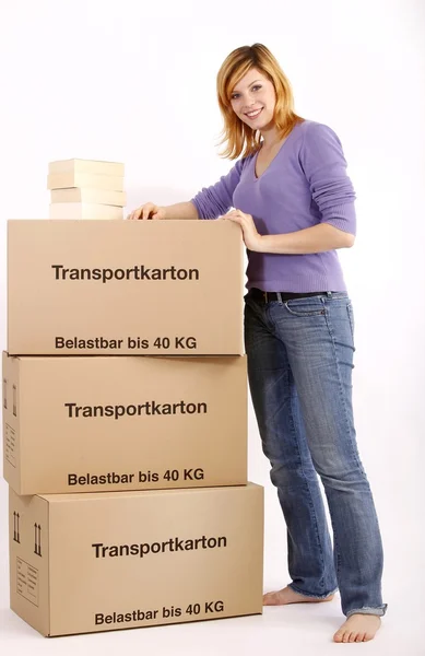 Young woman with moving box and books — Stock Photo, Image