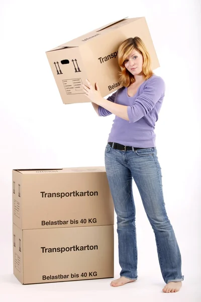 Young woman with moving boxes (white background) — Stock Photo, Image