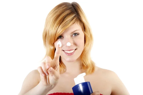 Mulher bonita aplicando creme cosmético no rosto — Fotografia de Stock