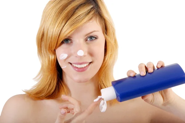 Bella donna che applica crema cosmetica sul viso — Foto Stock