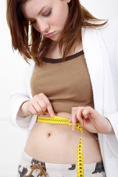 Mujer joven con cinta métrica alrededor de su cuerpo —  Fotos de Stock