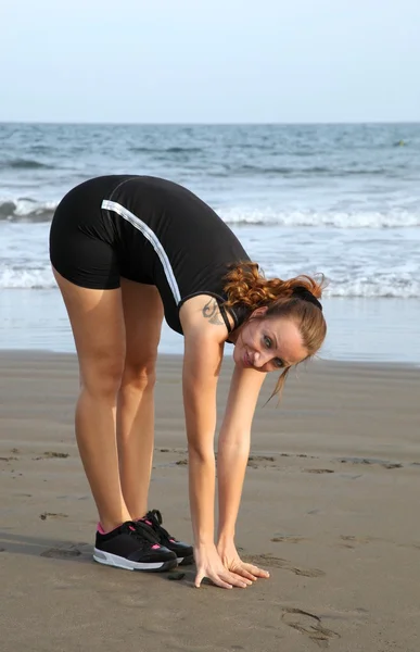 Mujer estirándose en la playa —  Fotos de Stock