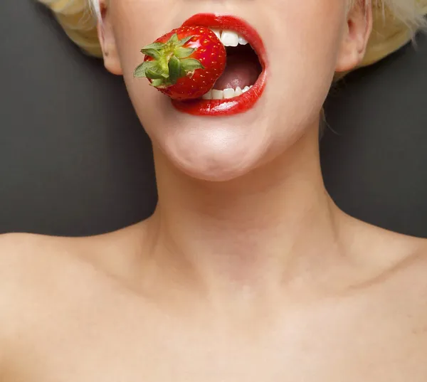 吃草莓的女人 免版税图库照片