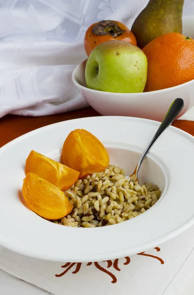 Sund morgenmad: Kamut, hørfrø, persimmon og pære - Stock-foto