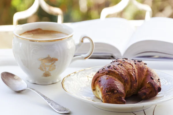 Caffè, croissant e libro — Foto Stock