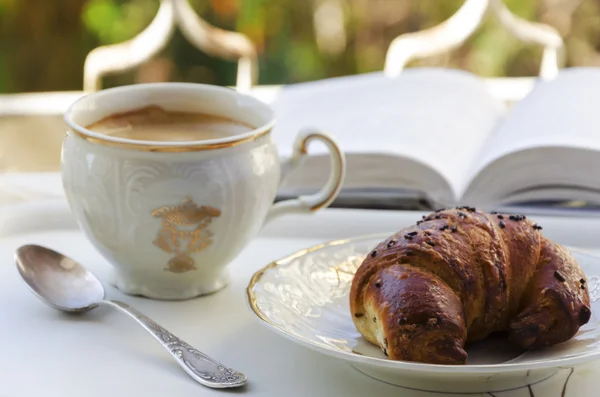 Kaffe, croissant och bok — Stockfoto